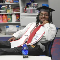 student posing wearing a graduation cap and stole