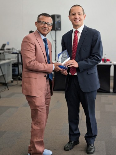 Dean presenting an award to Brett at the spring Board of Advisors meeting