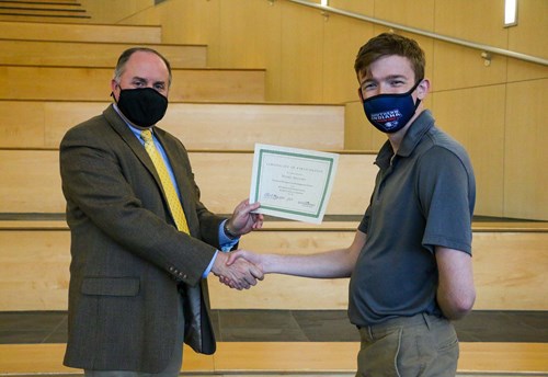 Thomas presenting certificate to Daniel