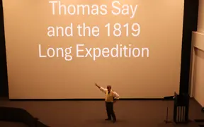 Presentation slide reading “Thomas Say and the 1819 Long Expedition” projected in a theater.