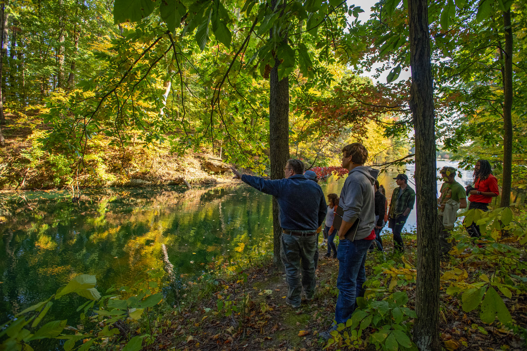 A geology class admires the sandstone lined natural lake on the Bent Twig Trails.