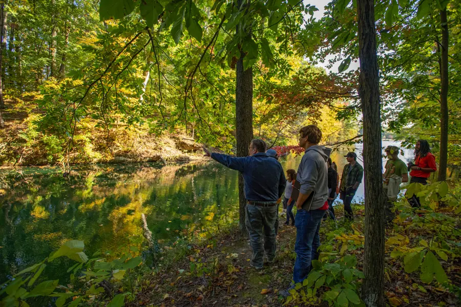 A geology class admires the sandstone lined natural lake on the Bent Twig Trails.