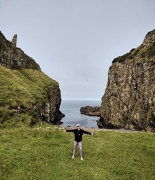 Meggie in front of cliffs and a sea