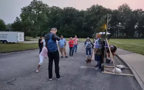 Group gathered around a photo op in the Atheneum parking lot