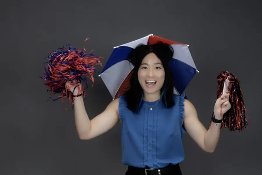 A member of the homecoming court, who always wears an umbrella hat and dancing on University Boulevard at new student orientation wears her umbrella hat and shakes pom poms.