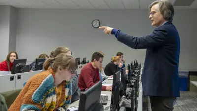 Sociology professor instructs students in a computer lab classroom