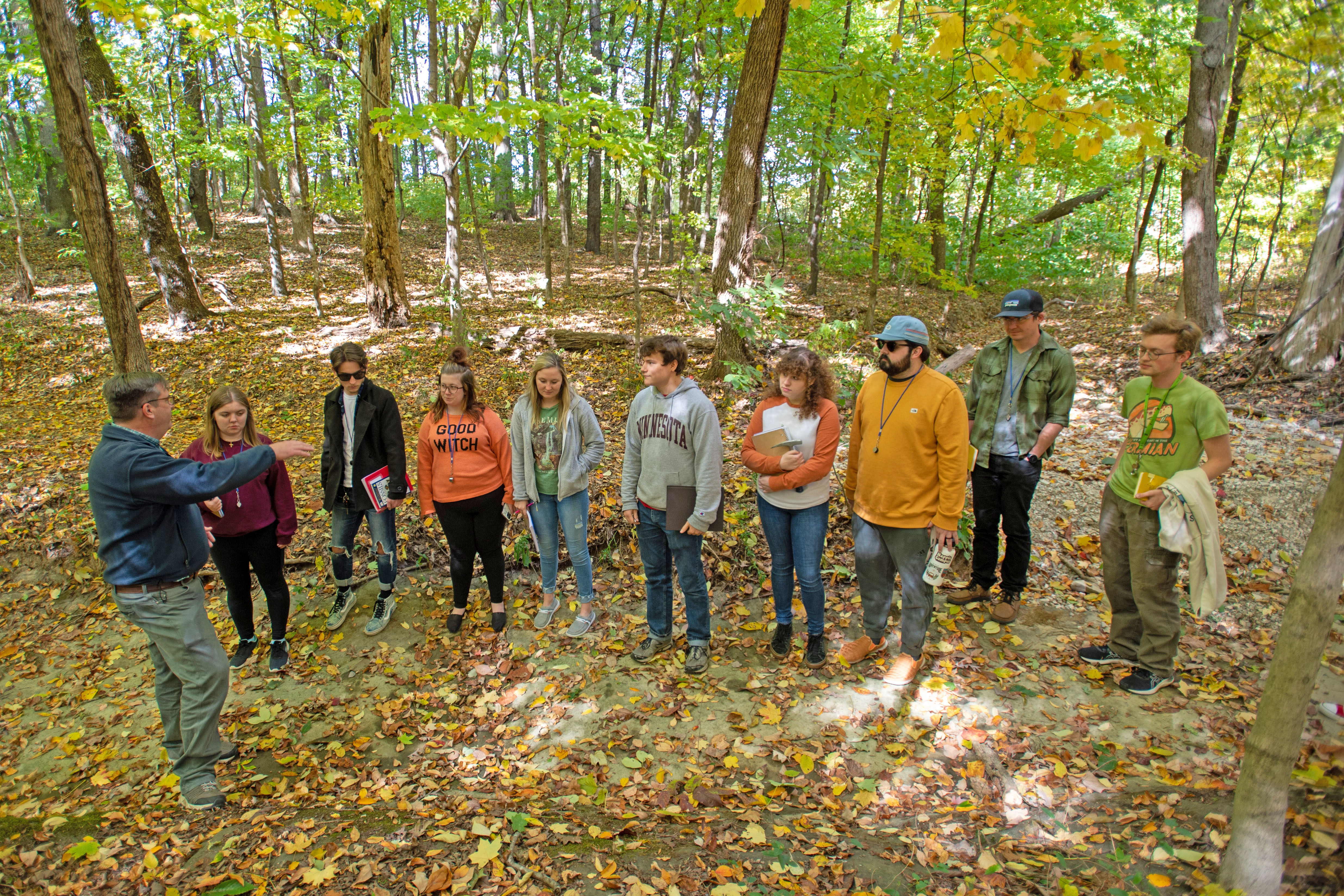 Geology students and their professor standing in a dry creek bed along the Bent Twig Trail. 