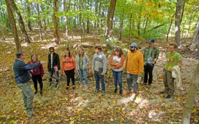 Geology students and their professor standing in a dry creek bed along the Bent Twig Trail. 