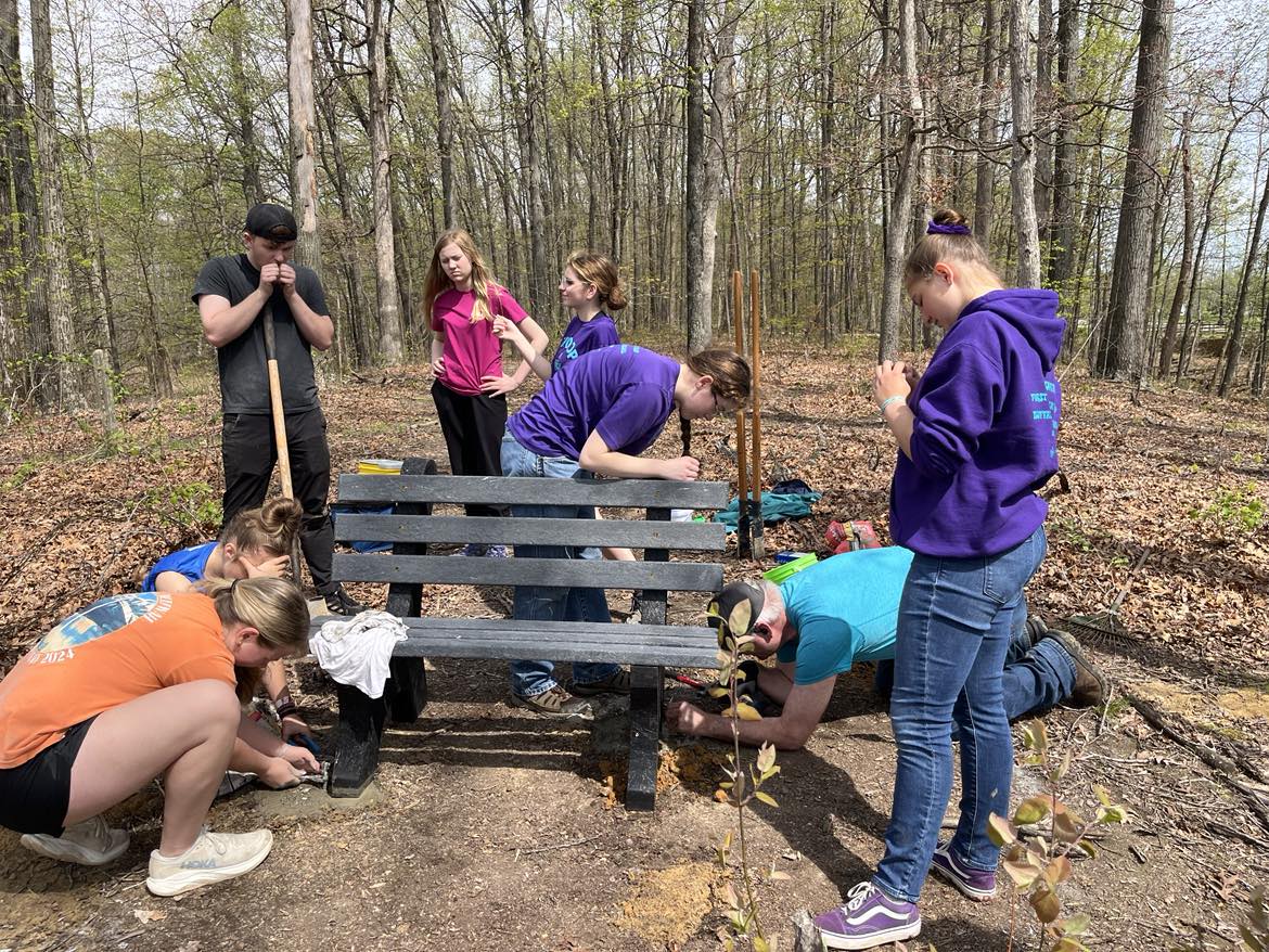 A Scouting Troop helps a fellow member install some benches on Bent Twig Trail as a way to earn her Eagle Scout Award.