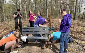 A Scouting Troop helps a fellow member install some benches on Bent Twig Trail as a way to earn her Eagle Scout Award.