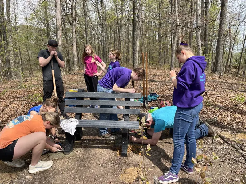 A Scouting Troop helps a fellow member install some benches on Bent Twig Trail as a way to earn her Eagle Scout Award.