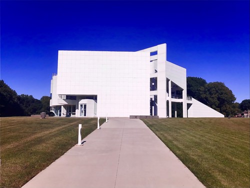 Photo of a modern white building set against a deep blue sky.
