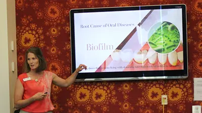 Photo of faculty member pointing to her presentation at a conference