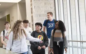 Business students walk across the 2nd floor balcony of the Business Engineering Center. 