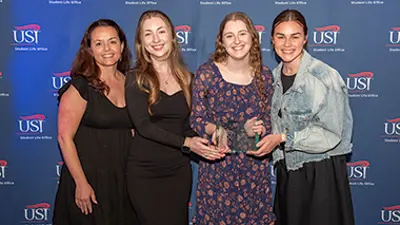 Members of student organization holding a trophy