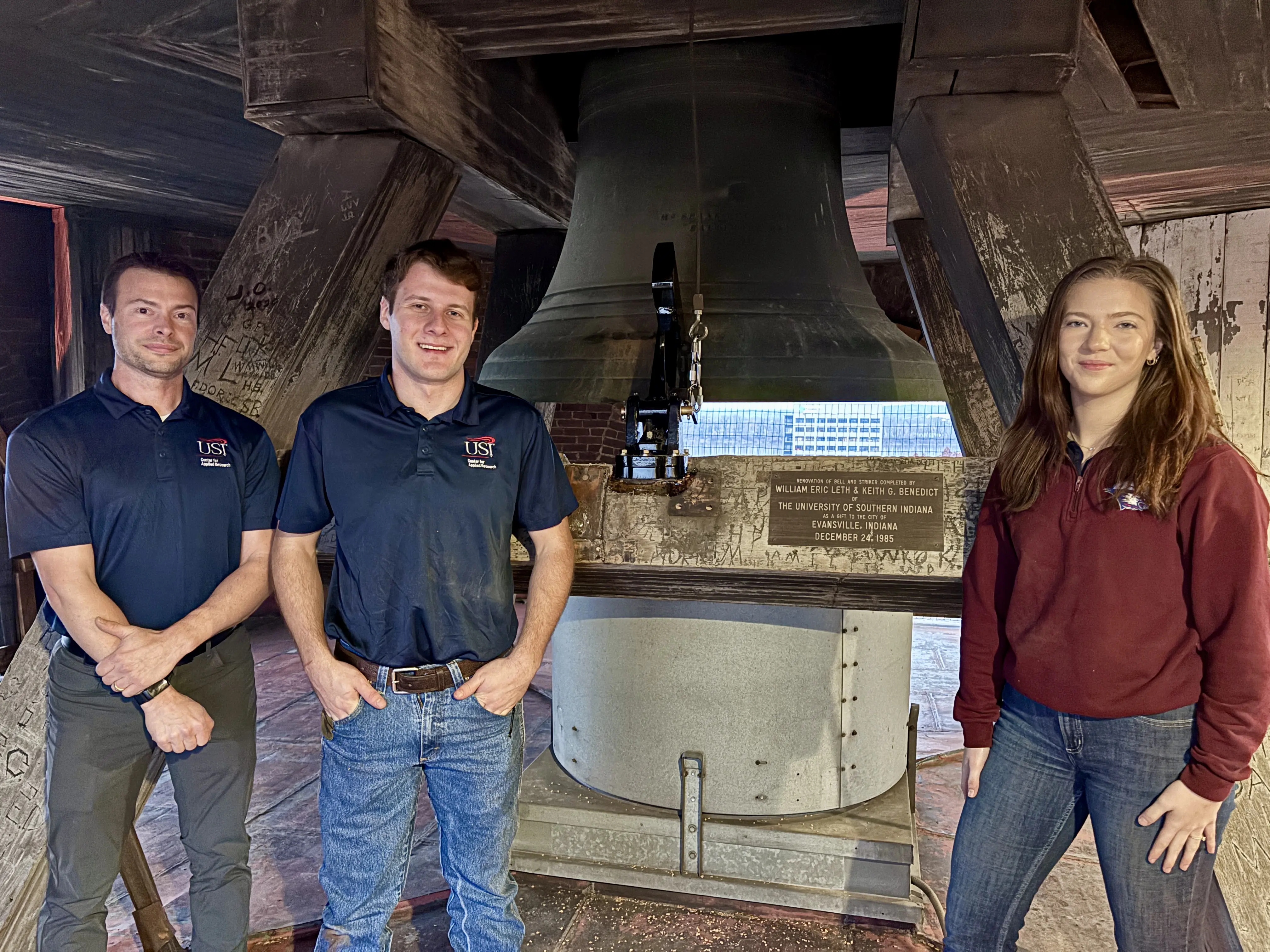Center for Applied Research team, Stump, Eickhoff and Voyles, pose in front of their handiwork on the bell.