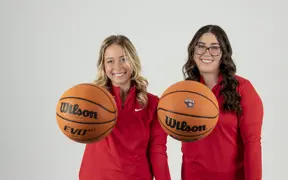 Two members of USI's Women's Golf team palm basketballs admirably during their golf media day photo shoot. 