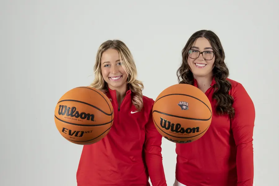 Two members of USI's Women's Golf team palm basketballs admirably during their golf media day photo shoot. 