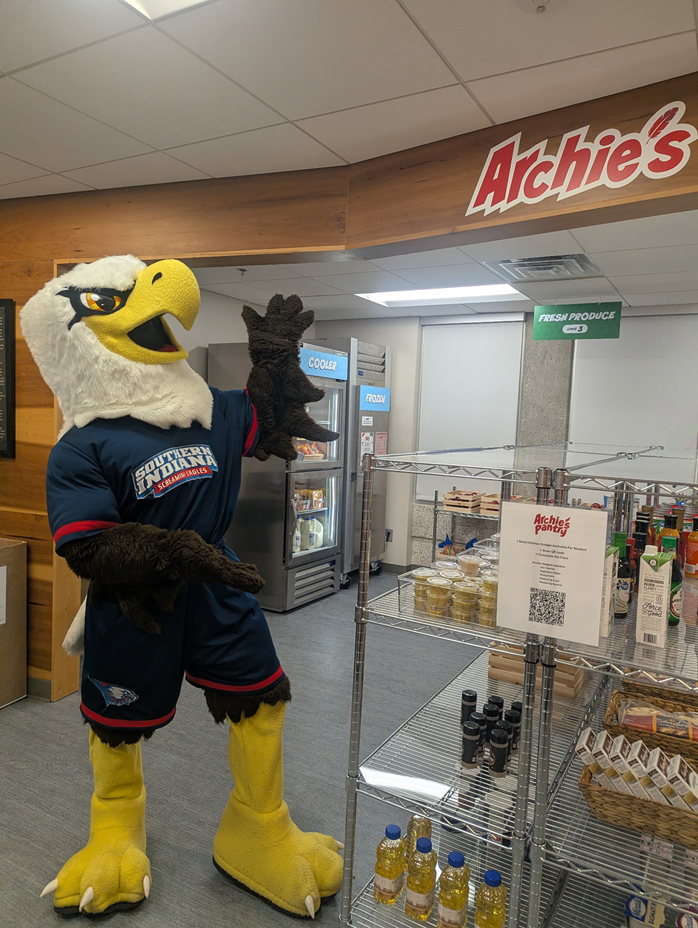 Archie pointing to the "Archie's Pantry" sign