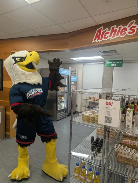 Archie pointing to the "Archie's Pantry" sign