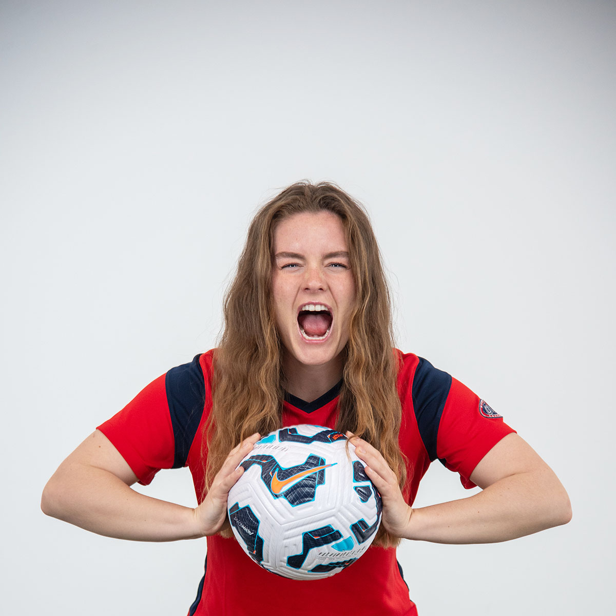 A women's soccer player lets out a yell in the photo studio during the soccer media day in the photo studio. 