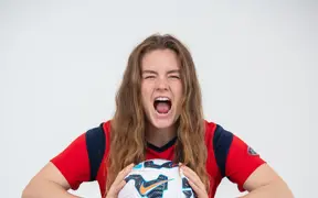 A women's soccer player lets out a yell in the photo studio during the soccer media day in the photo studio. 