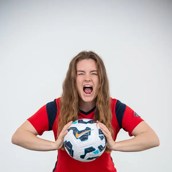 A women's soccer player lets out a yell in the photo studio during the soccer media day in the photo studio. 