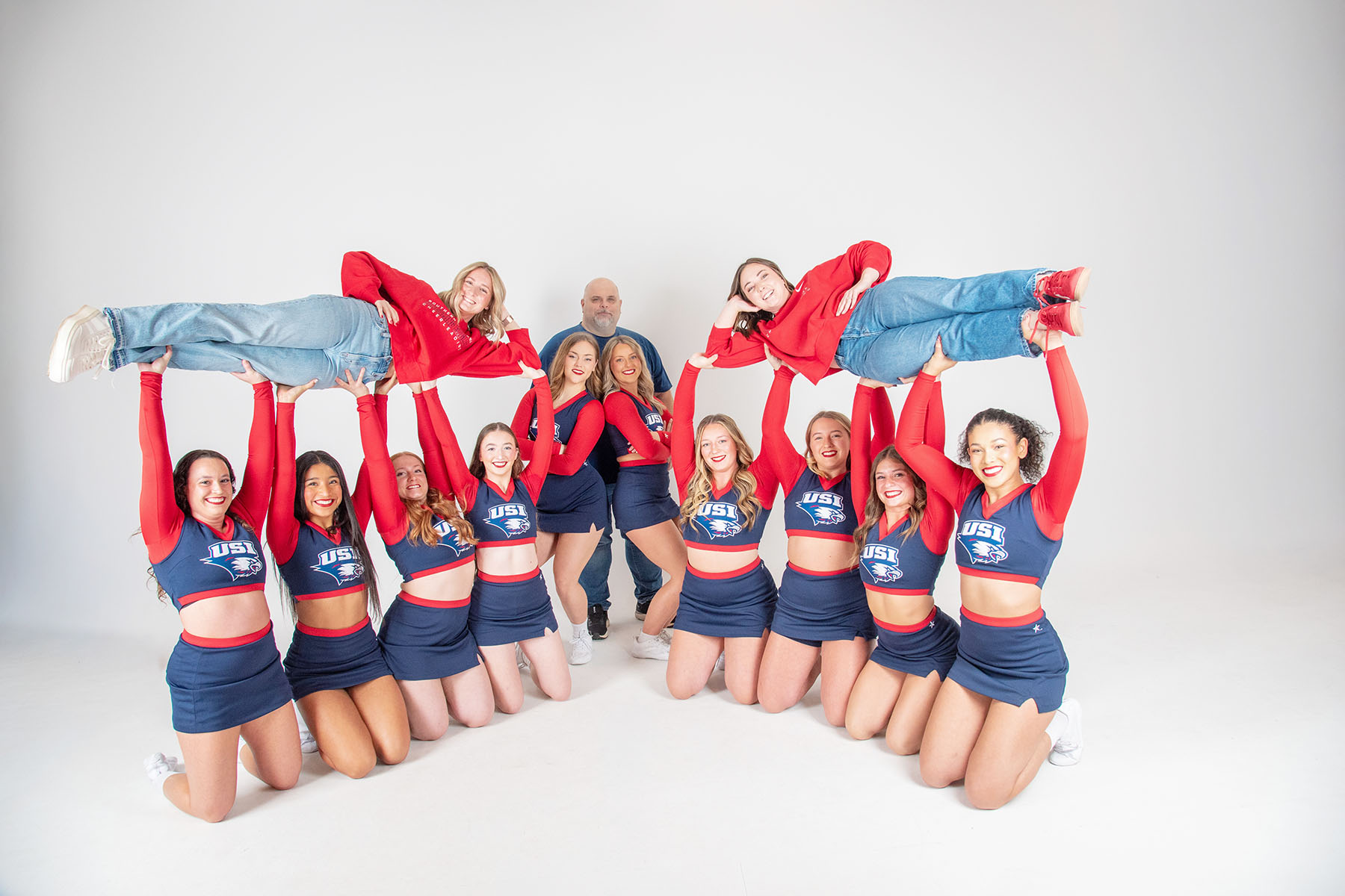 The USI cheer team lift their two long-time coaches in the air. 