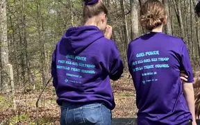 A Girl Scout/Scouting Troop pause to admire their work after installing a bench on the Bent Twig Trail.