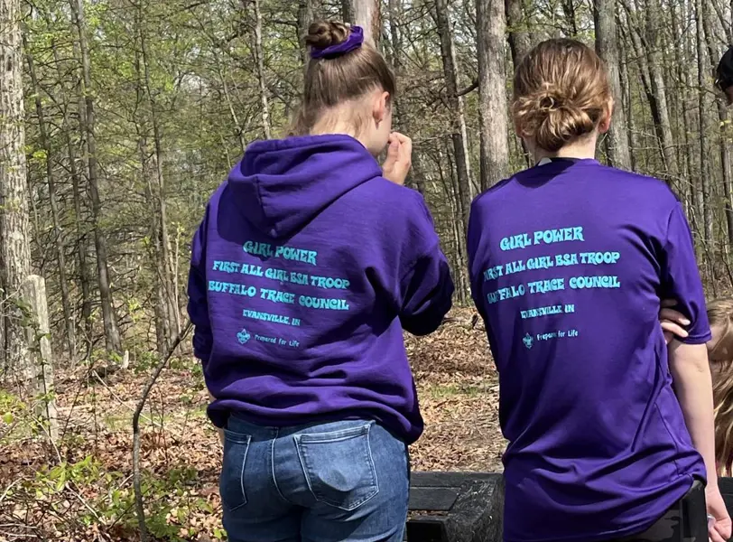 A Girl Scout/Scouting Troop pause to admire their work after installing a bench on the Bent Twig Trail.