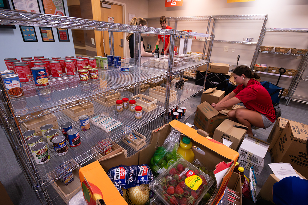 Student sorting food and putting it on shelves