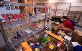 Student sorting food and putting it on shelves