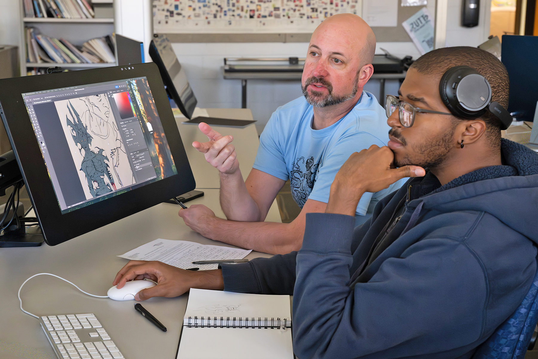 An art professor offers some constructive criticism to a student in a graphics class in the Art Center.