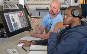 An art professor offers some constructive criticism to a student in a graphics class in the Art Center.