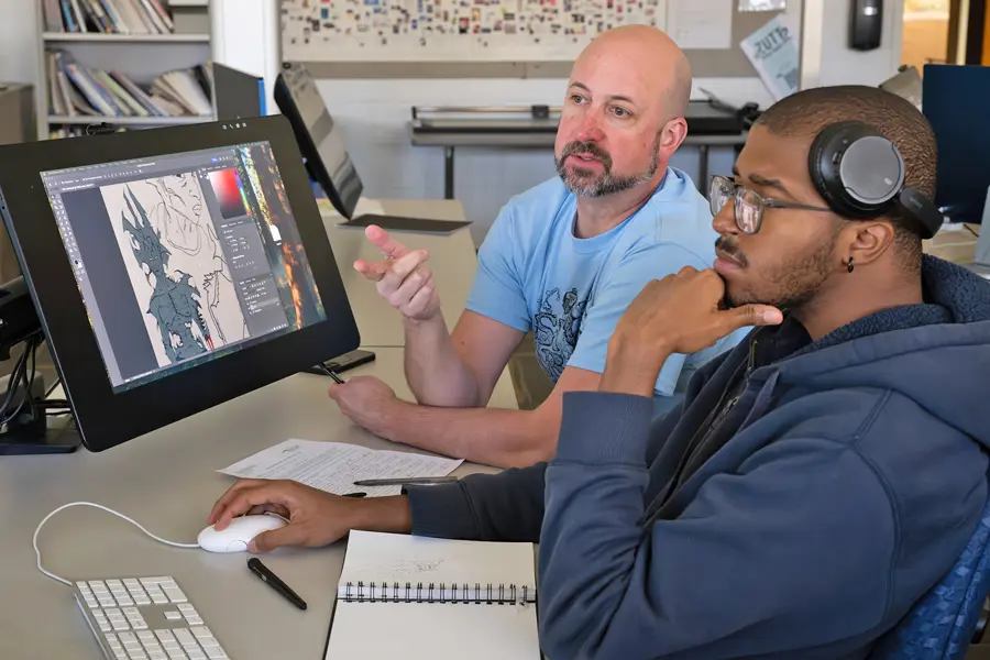 An art professor offers some constructive criticism to a student in a graphics class in the Art Center.