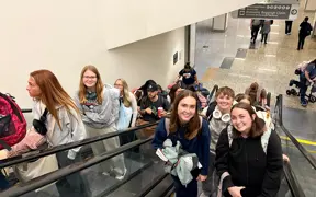 Students on airport escalator