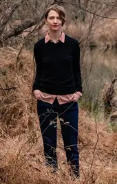 Amie Whittemore standing by a pond in the woods