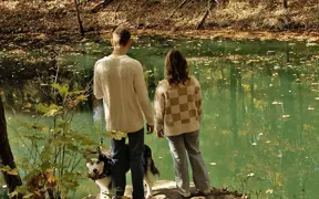 Students and their dog pause at a rock overlook on the Bent Twig Trails. 