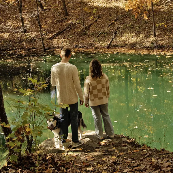 Students and their dog pause at a rock overlook on the Bent Twig Trails. 