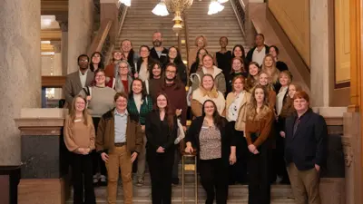 Social work students pose for a group photo on steps