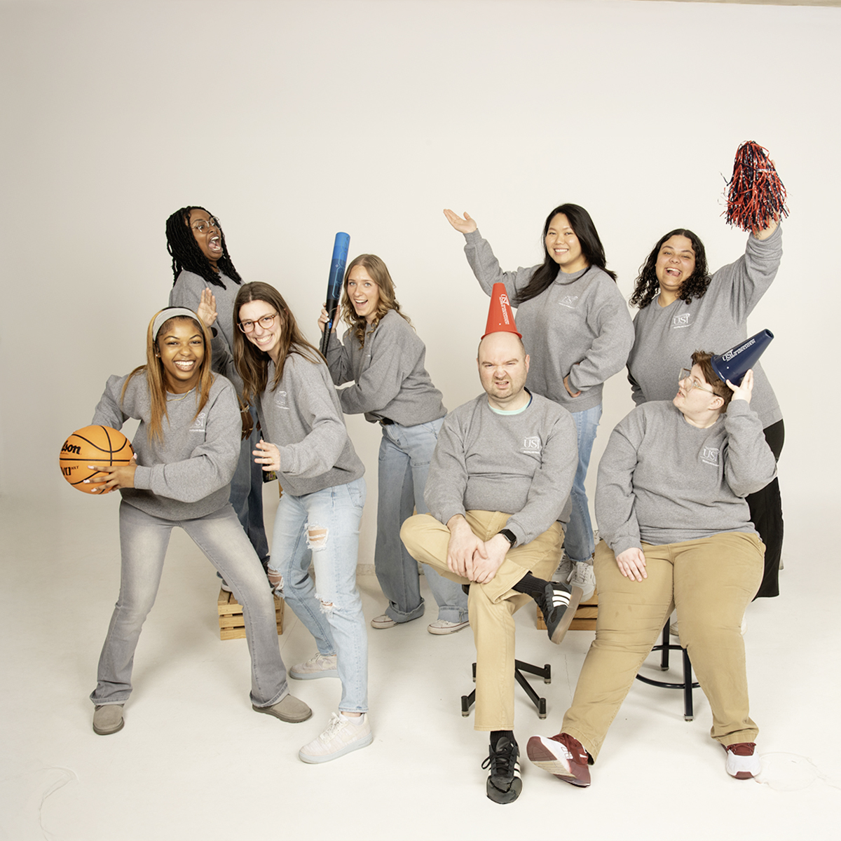 Housing and Residence Life staff  play with athletic props for their informal group photo.