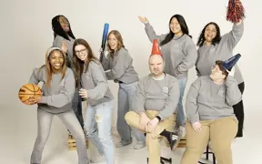 Housing and Residence Life staff  play with athletic props for their informal group photo.
